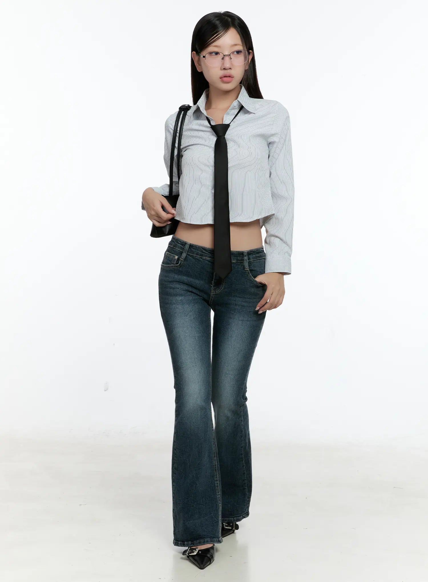Harlee Bootcut Jeans CS517 in dark blue, full-length front outfit shot on model, low-rise washed bootcut silhouette paired with a cropped stripe shirt, black tie, and buckle heels.