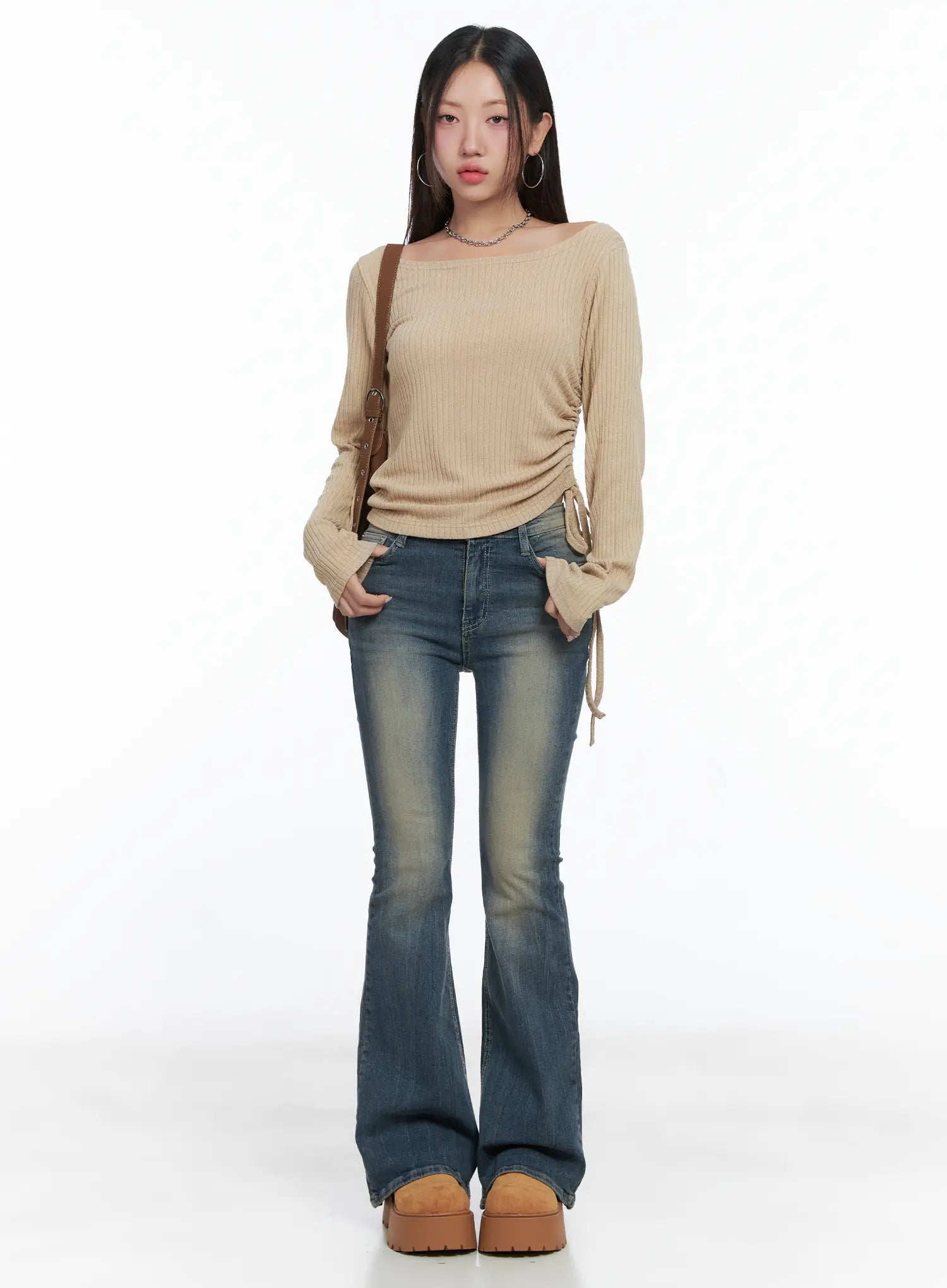 Sloan Vintage Hip Pad Flare Jeans CS502 in dark blue, full-length front outfit shot, model wearing beige ribbed ruched top and crossbody bag, long flare hem, acubi casual style.