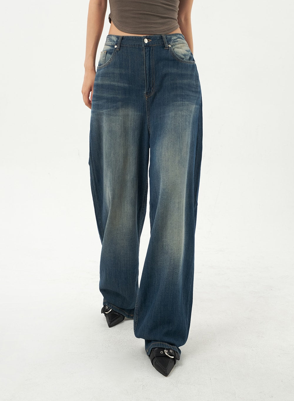 Baggy Low Rise Jeans CA326 in dark blue, waist-to-hem front close-up on model, low-rise five-pocket denim with contrast fading and wide floor-grazing leg, black pointed heels.