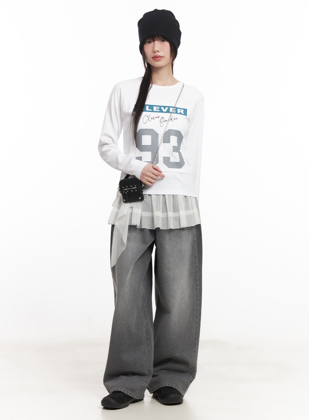Venessa Washed Baggy Jeans CM528 in dark gray, full-body editorial shot on model, styled with graphic long-sleeve tee, pleated layer, beanie, and mini chain bag.