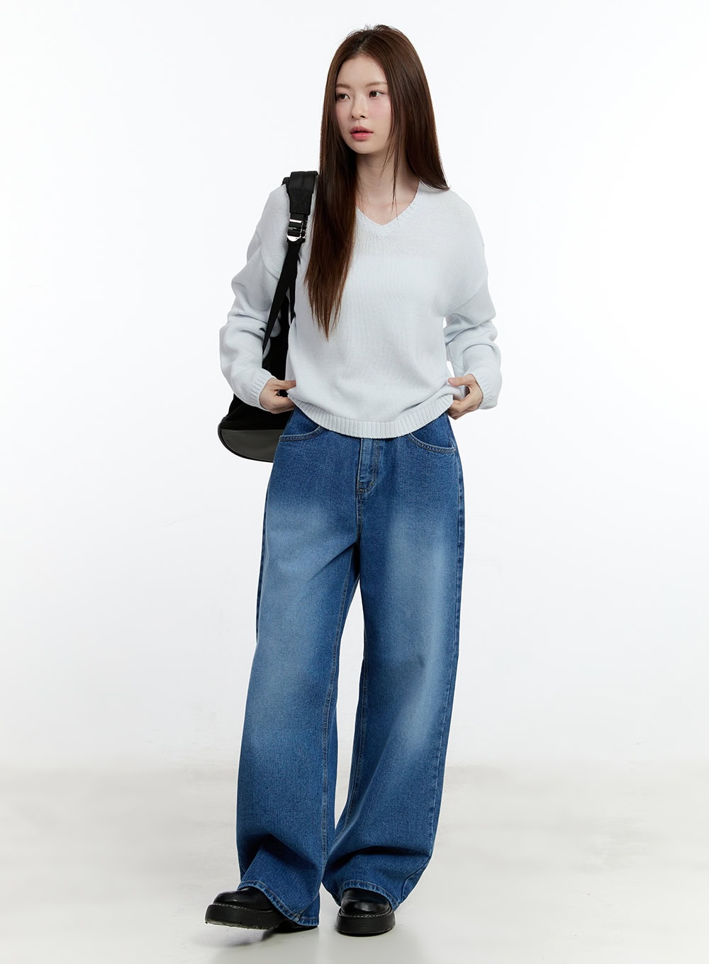 Eugene Adjustable Cinched-Back Wide-Leg Jeans CM521 in dark blue, full-body front shot on model, relaxed wide-leg washed denim, styled with white knit sweater, black shoulder bag, and black loafers.