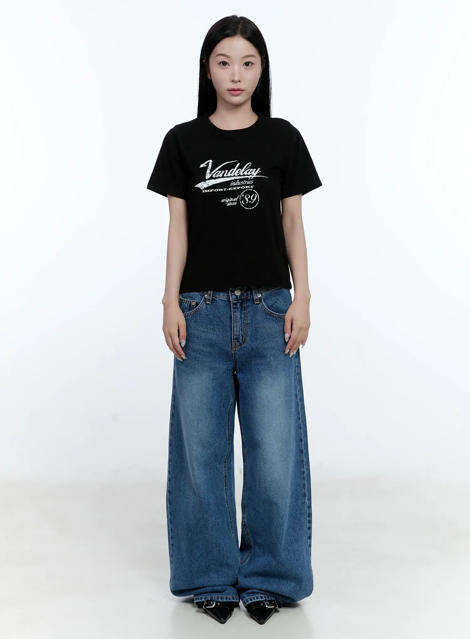 Dahye Washed Relaxed-Fit Denim Jeans CL530 in blue, full-body front view on model, wide-leg long silhouette with washed cotton denim, styled with a black graphic tee and black heels.