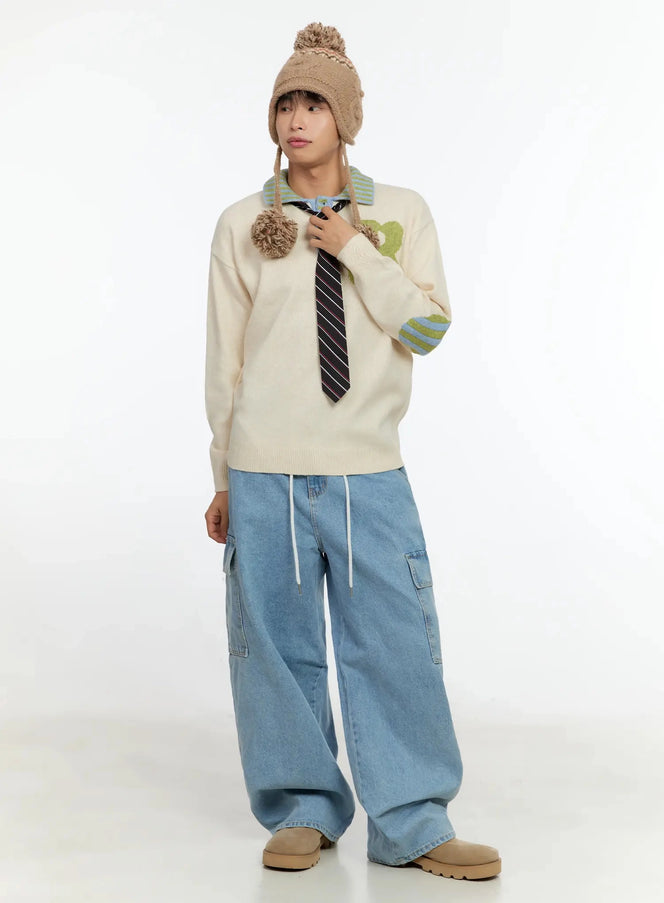Men's Graphic Collar Sweater IN506 in light beige, full-body front on model, striped polo collar with buttons, green B graphic, striped elbow patch, paired with wide cargo jeans.