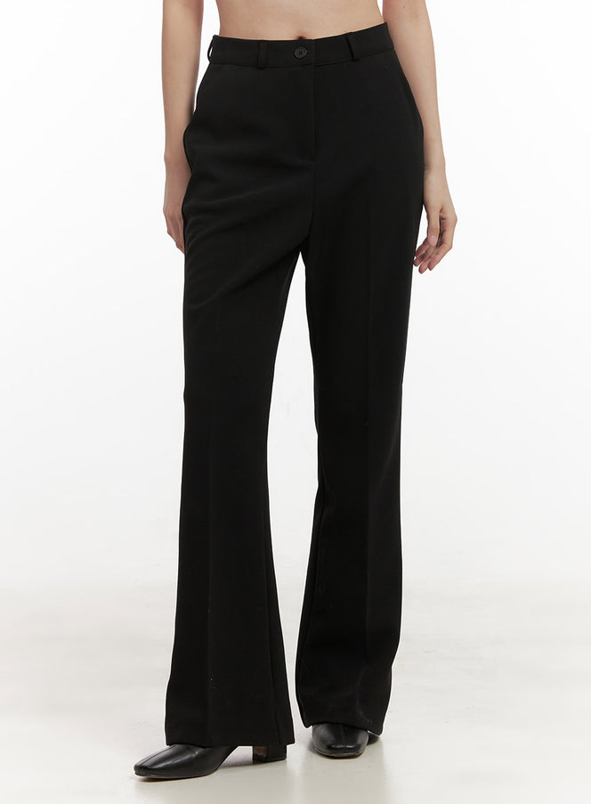 Classic Chic Tailored Pants OD417 in black, front close-up on model, high-waist button closure with belt loops, flared leg and center crease, worn with black square-toe heels.