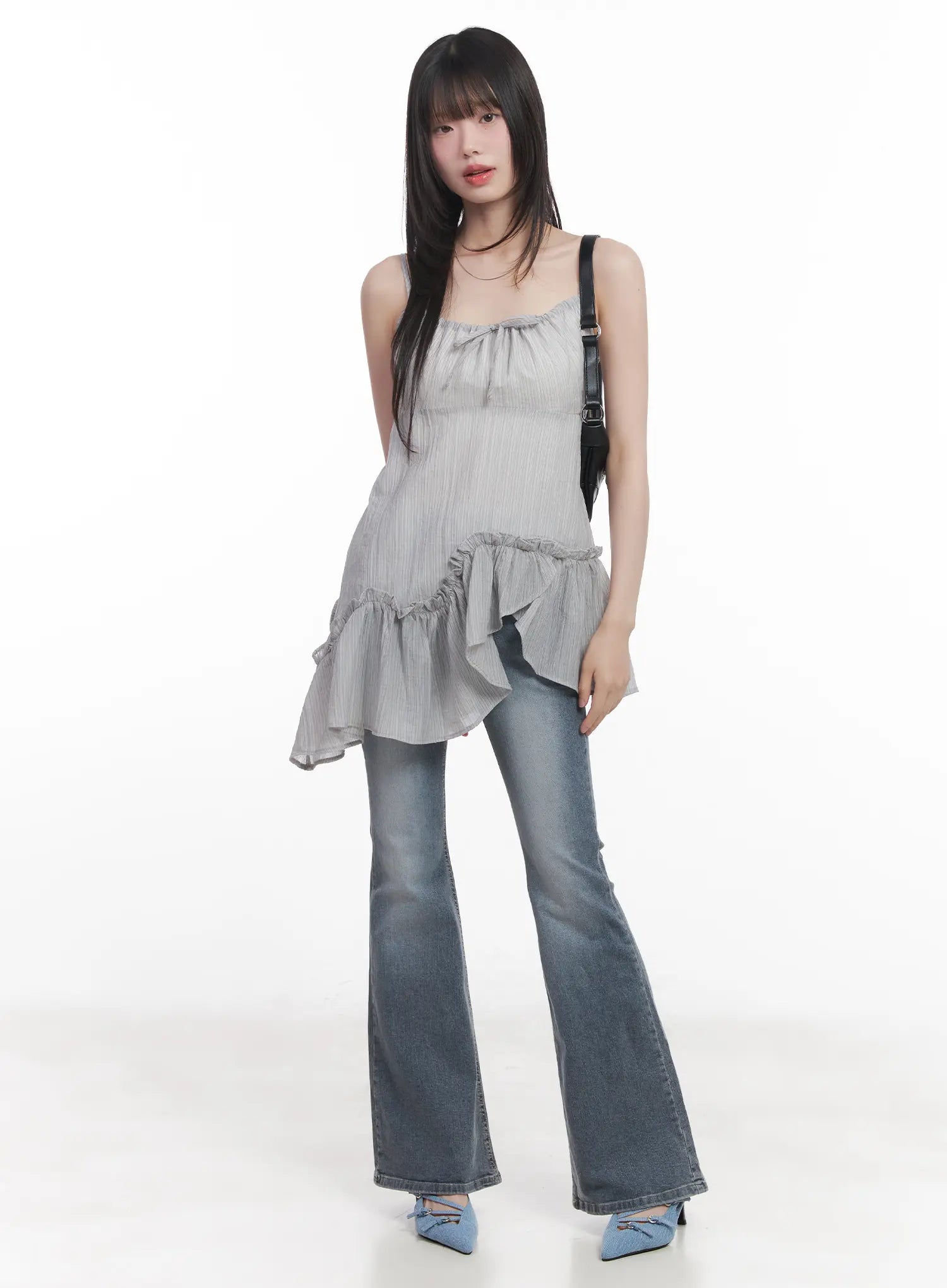Soyeon Flared Jeans with Hip Pads CU520 in dark gray, full-body front on model, washed flared denim styled with ruffle cami top and black shoulder bag, blue heels.