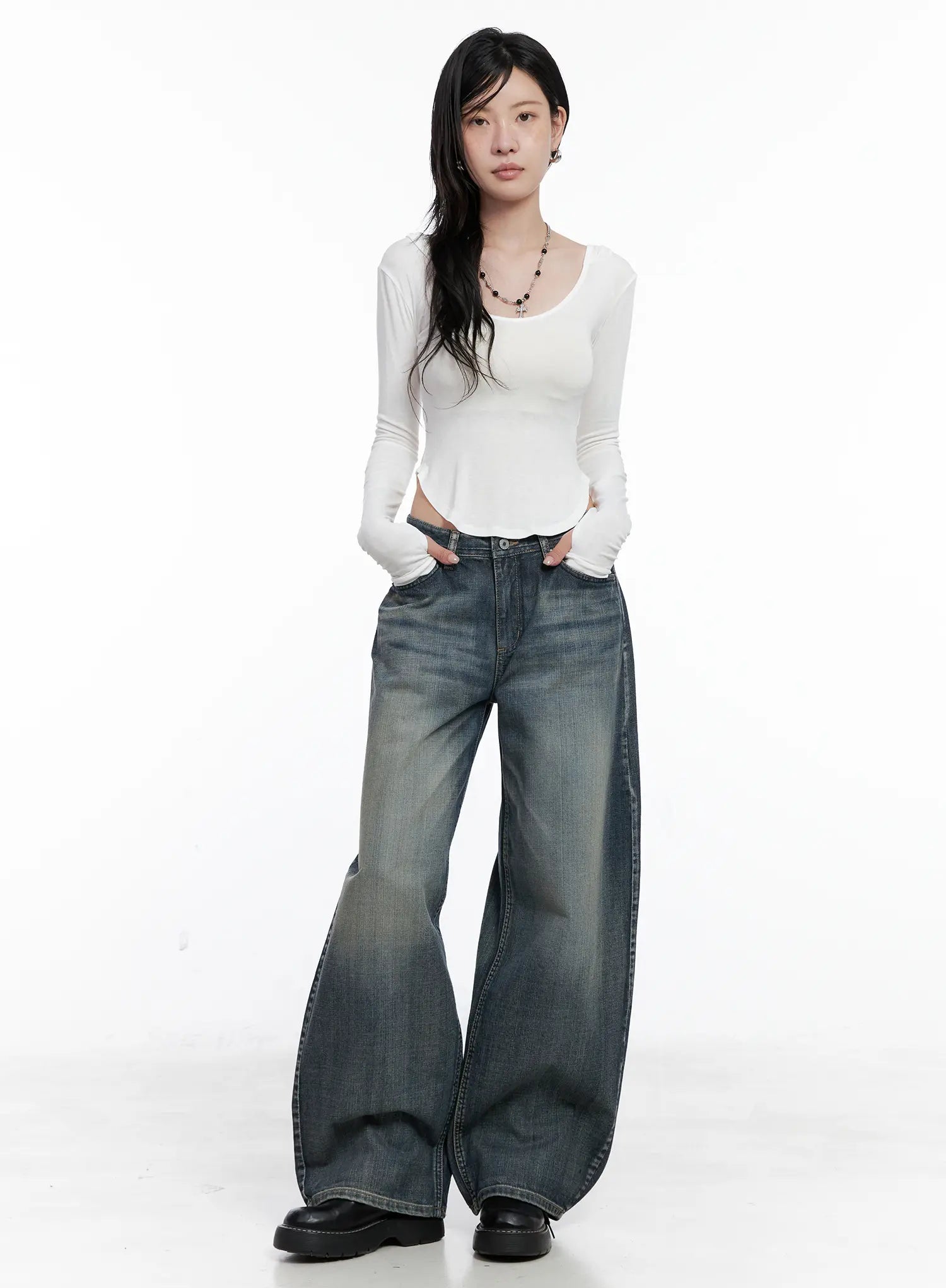 Nellie Baggy Jeans CS526 in blue, full-body front on model, wide-fit washed denim styled with white long-sleeve crop top and beaded necklace, floor-grazing length.