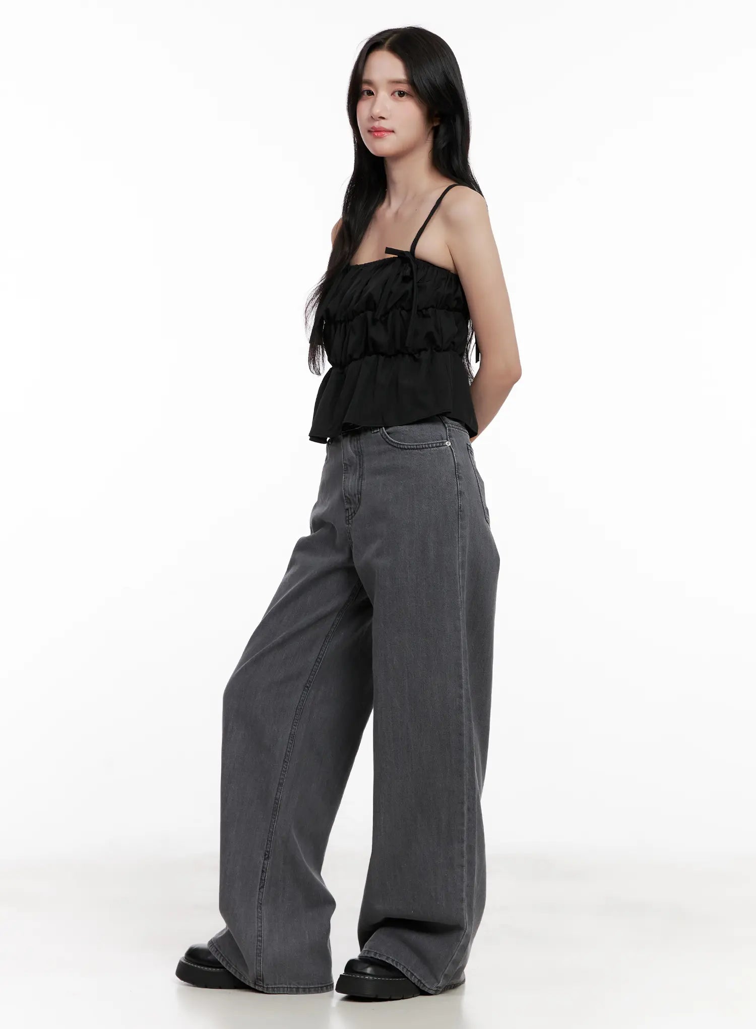 Jiyeon Dark Gray Denim Jeans CL516 in dark gray, side-angle full-body shot on model, wide-leg long silhouette paired with black ruffled cami top and black loafers.