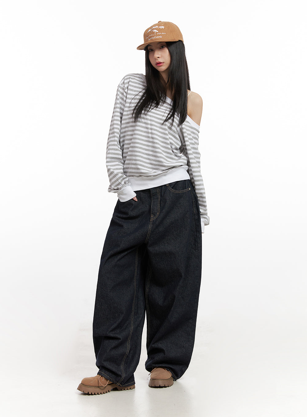 Lily Stitched Wide-Leg Jeans CN426 in dark blue, full-length front shot on model, oversized wide-leg denim with contrast stitching, styled with off-shoulder striped top and brown cap.