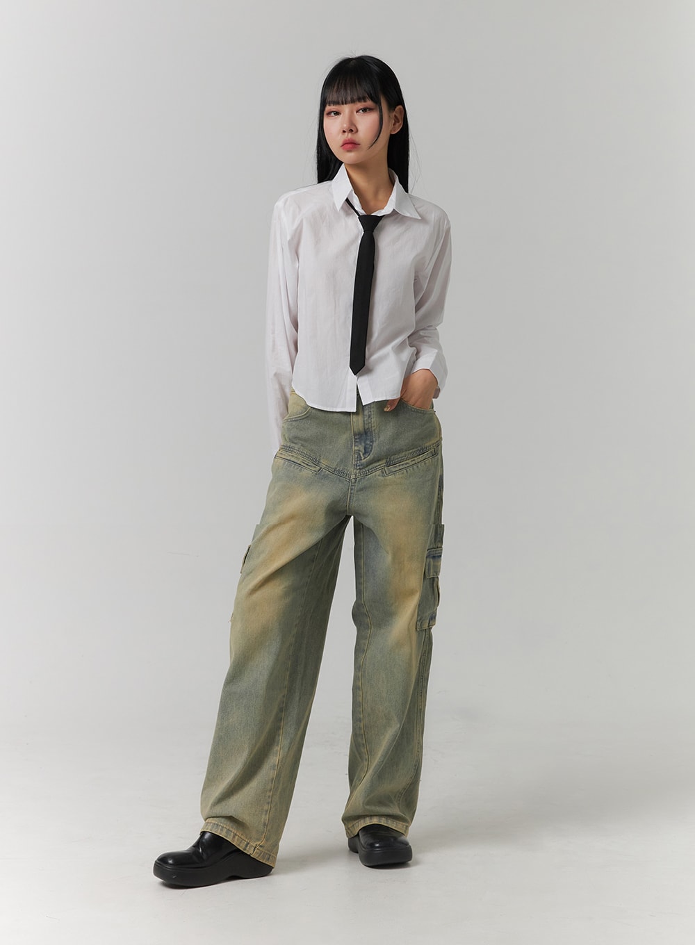 Cargo Denim Straight Leg Jeans CJ422 in blue, full-body front view on model, hand in pocket, wide-fit acid-washed denim with side cargo pockets, paired with white cropped shirt and black tie.