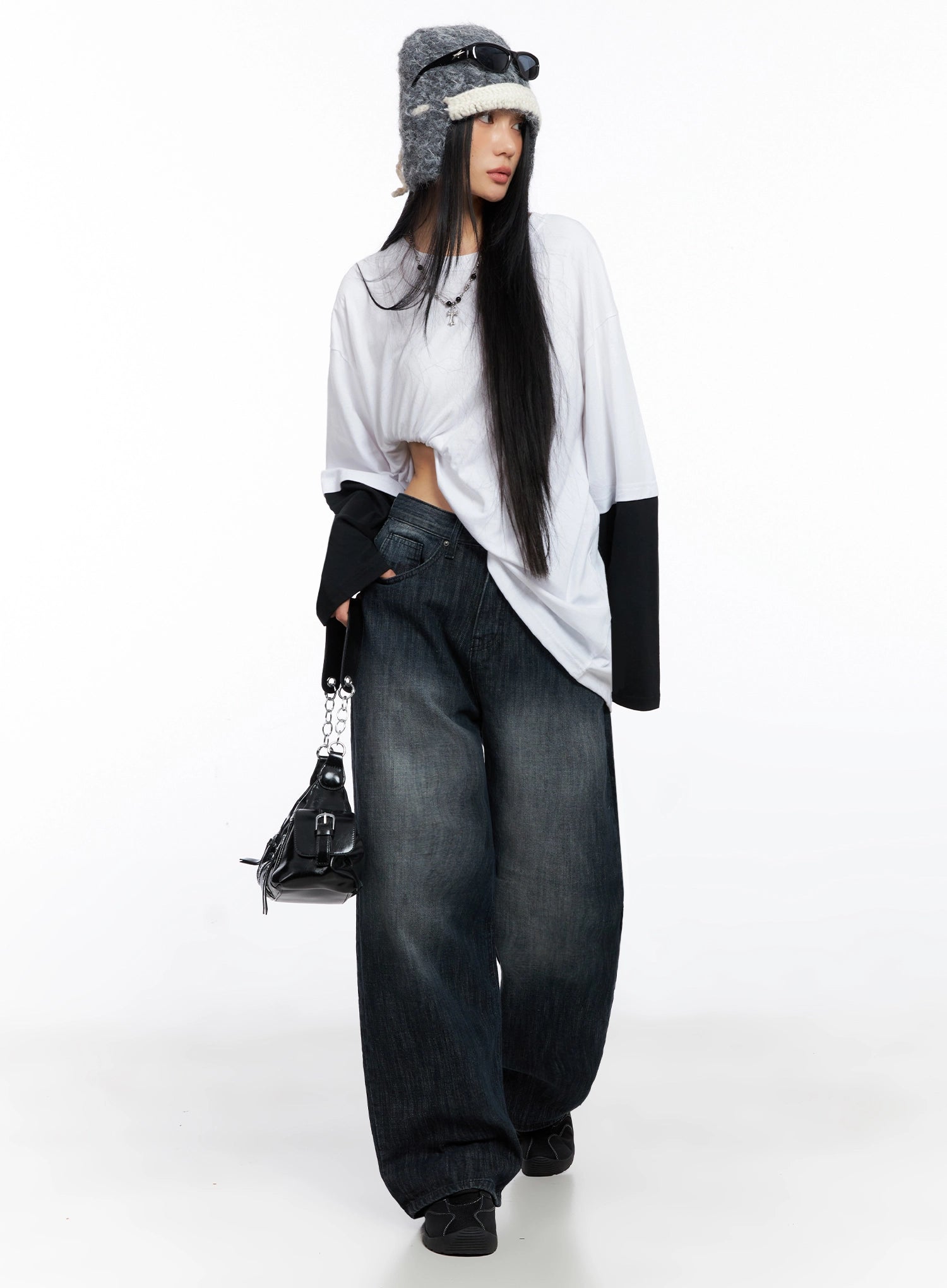 Minnell Vintage-Wash Wide-Leg Jeans IO517 in dark blue, full-body editorial shot, model wearing white layered tee and fuzzy trapper hat, holding black chain bag, street style.