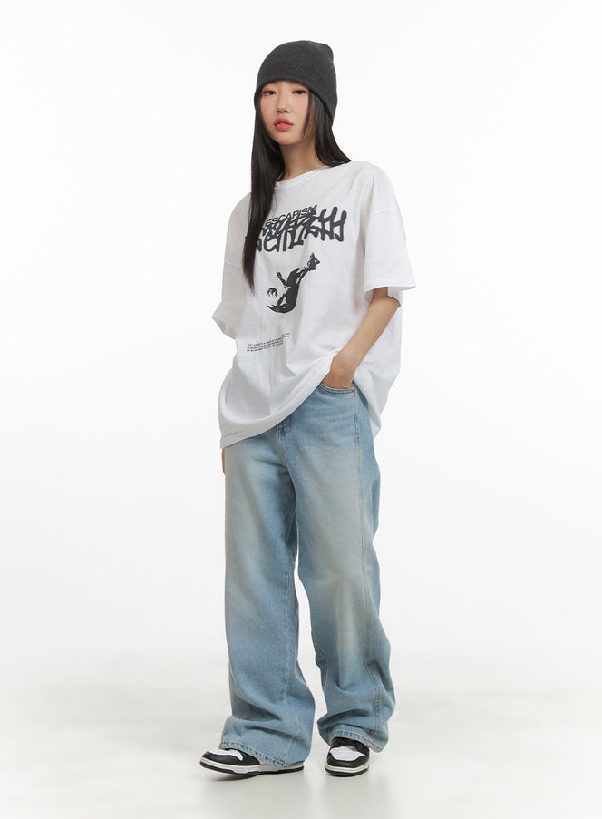 Graphic Oversized T-Shirt CY423 in white, full-body front view on model, relaxed oversize cotton tee with street graphic print, paired with wide-leg light blue jeans and sneakers.