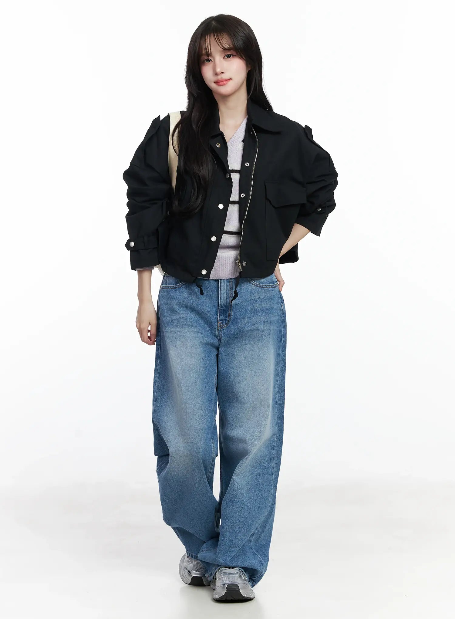 Iliana Wide Leg Jeans IJ529 in blue, full-body front shot on model walking, wide-leg washed denim styled with black cropped jacket and striped knit top, silver sneakers.