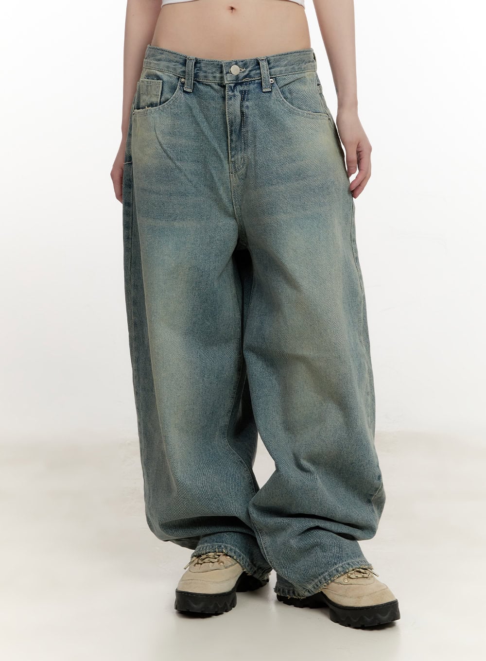 LEWKIN Galinda Washed Baggy Jeans CM513 in vintage blue, front view on model, wide-fit cotton denim with yellow-tinted wash, low rise waistband, pooling hem over chunky sneakers.