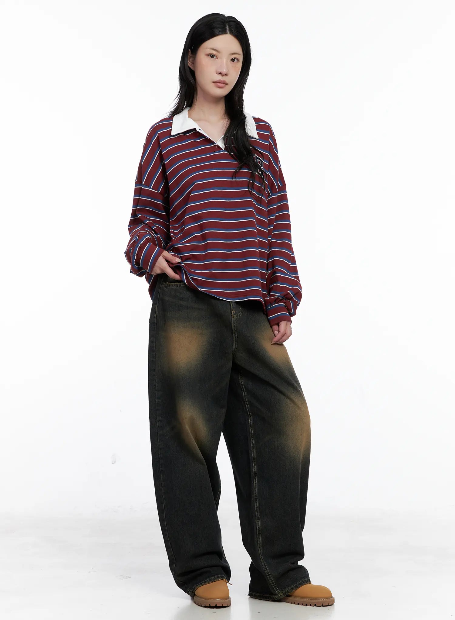 Leona Vintage Baggy Jeans CS526 in dark blue, full-body front shot on model, baggy wide-leg fit with vintage amber wash, styled with striped rugby polo and tan boots.