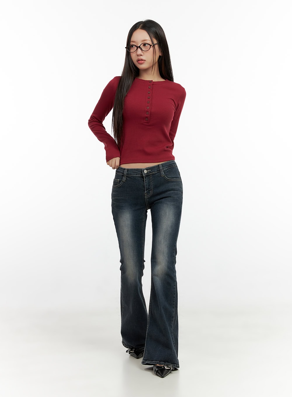 Ingrid Low-Rise Washed Flared Hip Pad Denim Jeans CN404 in dark blue, full-body front shot on model, low-rise waistband, wide flared hem, styled with red cropped henley top and black heels.