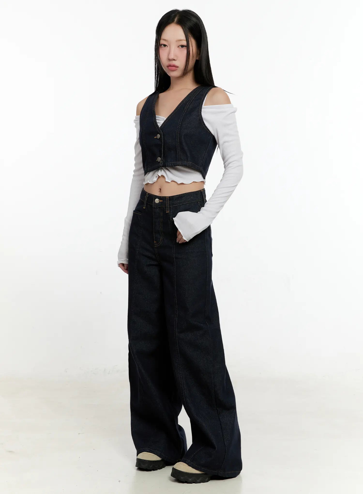 Nala Wide-Leg Bootcut Jeans CN506 in dark blue, full-length 3/4 angle on model styled with a denim vest and white off-shoulder long-sleeve top, floor-grazing wide leg.