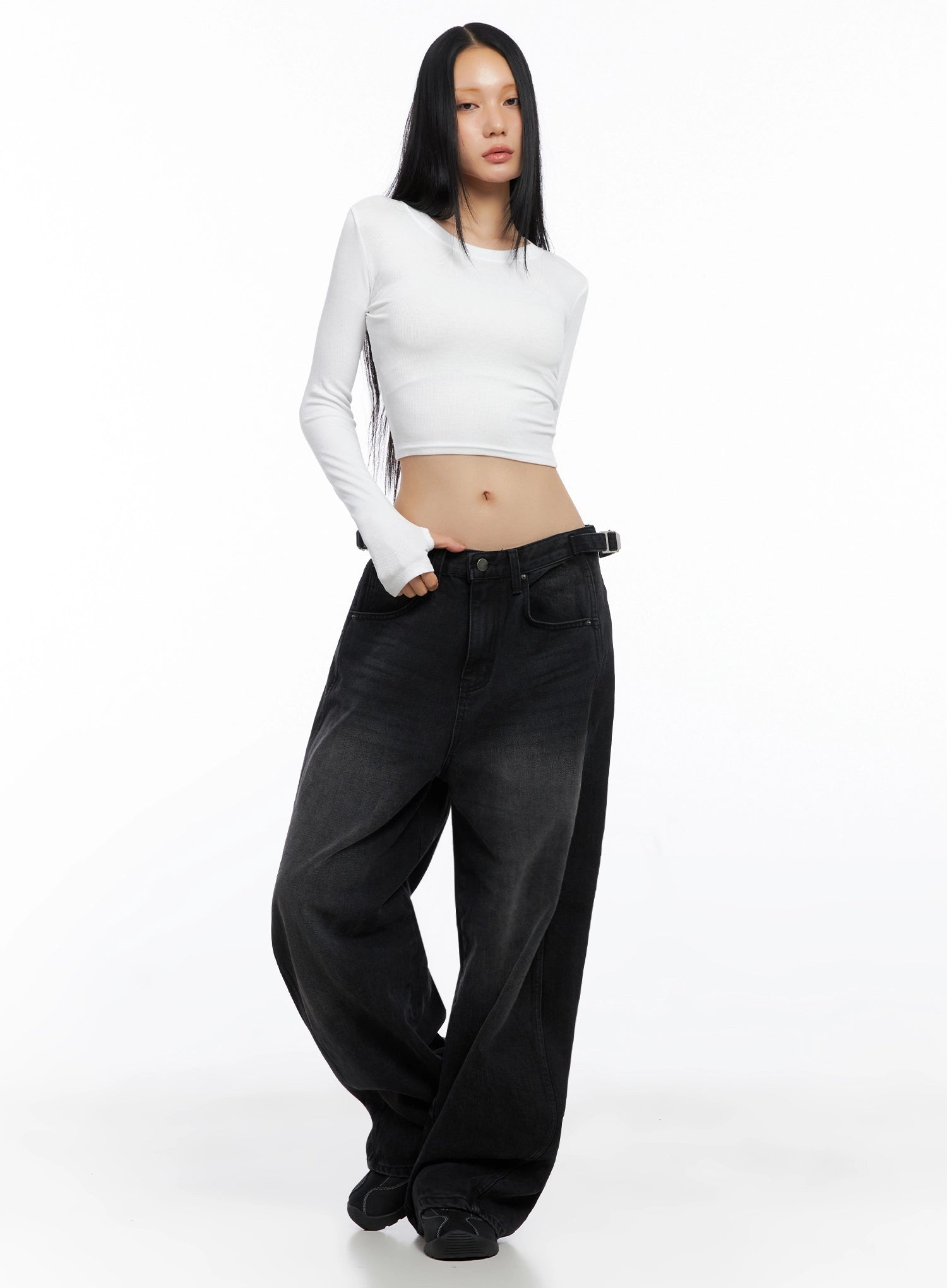 Goffel Side Belt Washed Wide Denim Pants IO517 in black, full-body front shot on model, low-rise wide fit with washed finish, styled with white crop long-sleeve top and black sneakers.
