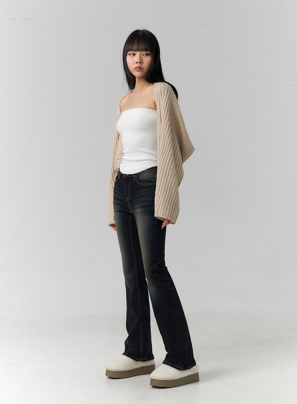 Washed Low Rise Bootcut Jeans CD308 in dark blue, three-quarter front angle on model, slim bootcut silhouette with contrast stitching, paired with white tube top and beige open-front cardigan.