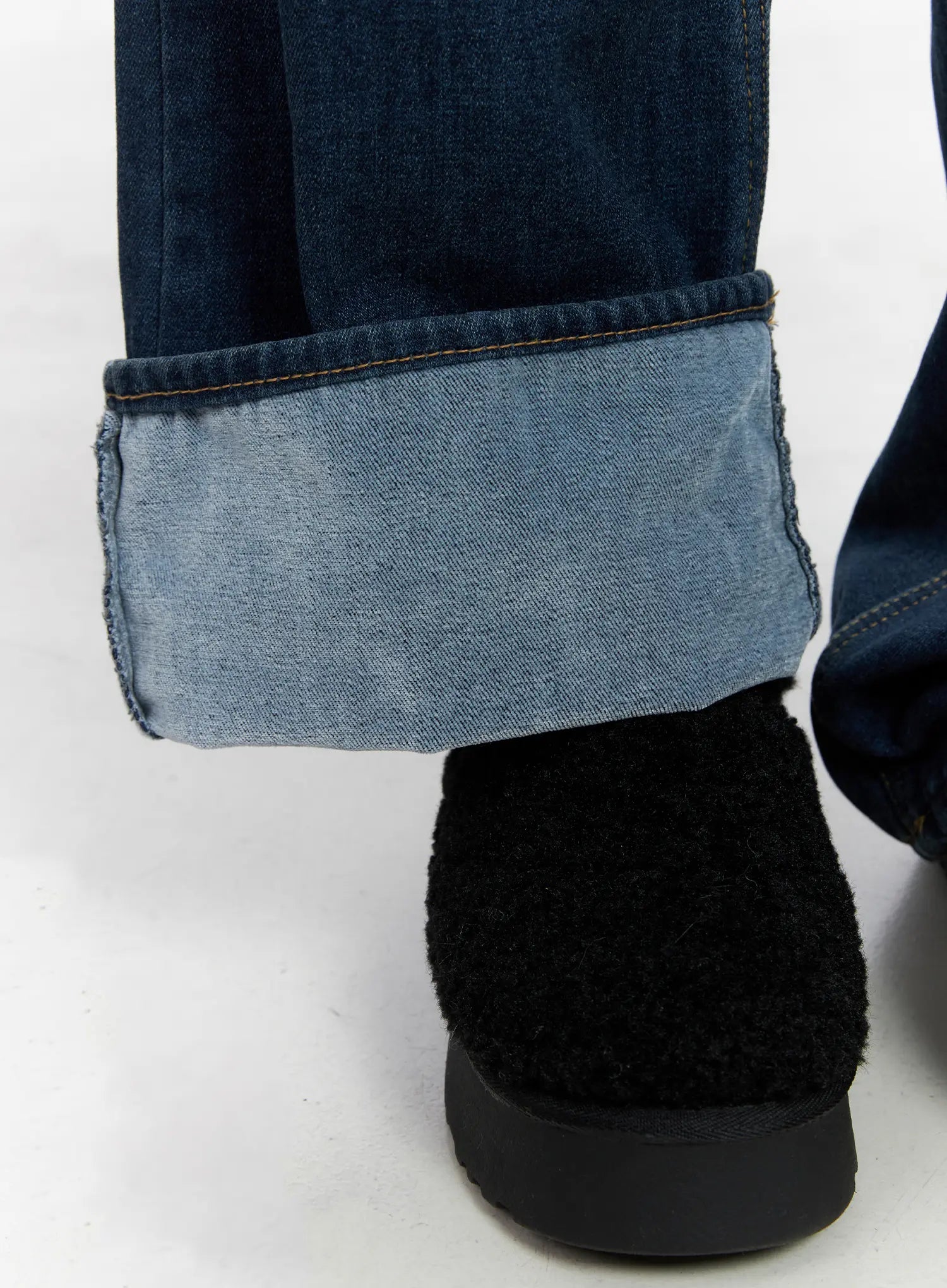 Jordan Velvet Fleece Wide Jeans CN518 in blue, extreme close-up of rolled hem cuff detail revealing lighter inside wash, contrasting two-tone denim fabric texture.