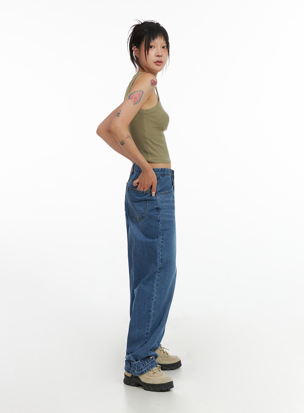 Wide Leg Baggy Jeans CL415 in blue, side profile full-body shot on model, washed denim with relaxed wide leg and deep side pocket, paired with olive tank and chunky sneakers.
