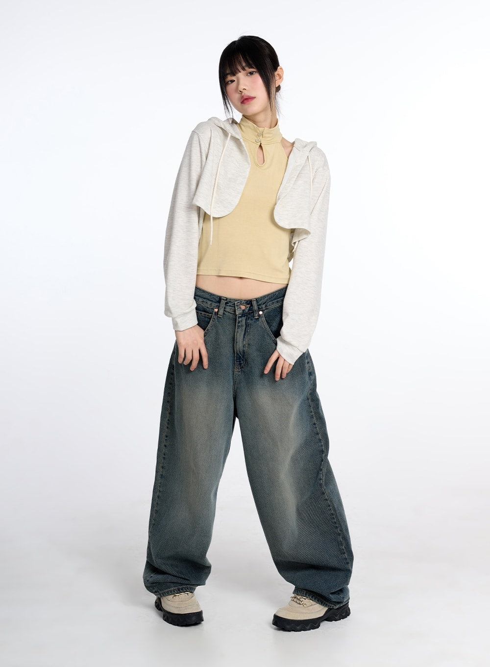 Vintage Low Rise Baggy Jeans CM415 in dark blue, full-body front shot on model, street-style outfit with cropped hoodie layered over yellow turtleneck crop top and chunky sneakers, acubi aesthetic.