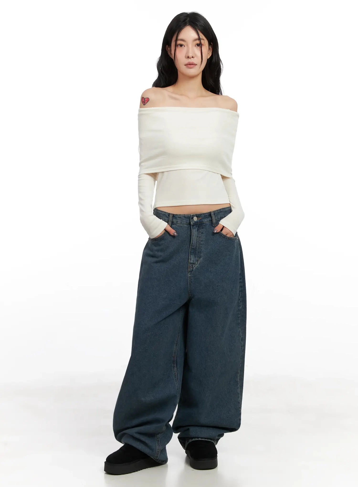 Aleena Mid-Wash Baggy Jeans IN528 in dark blue, full-front shot on model in white off-shoulder crop top, hands in pockets, showing low-rise waist and extremely wide leg silhouette.