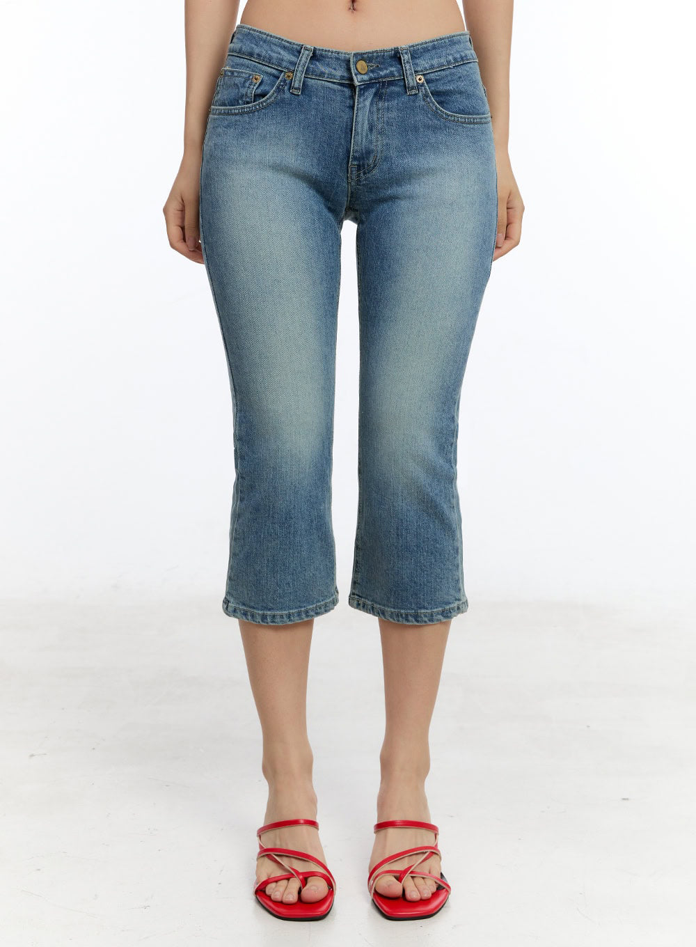 Kyra Cropped Low-Rise Skinny Jeans IU503 in blue, front product shot on model, washed denim low-rise waistband and gold button detail, cropped hem, paired with red strappy mules.
