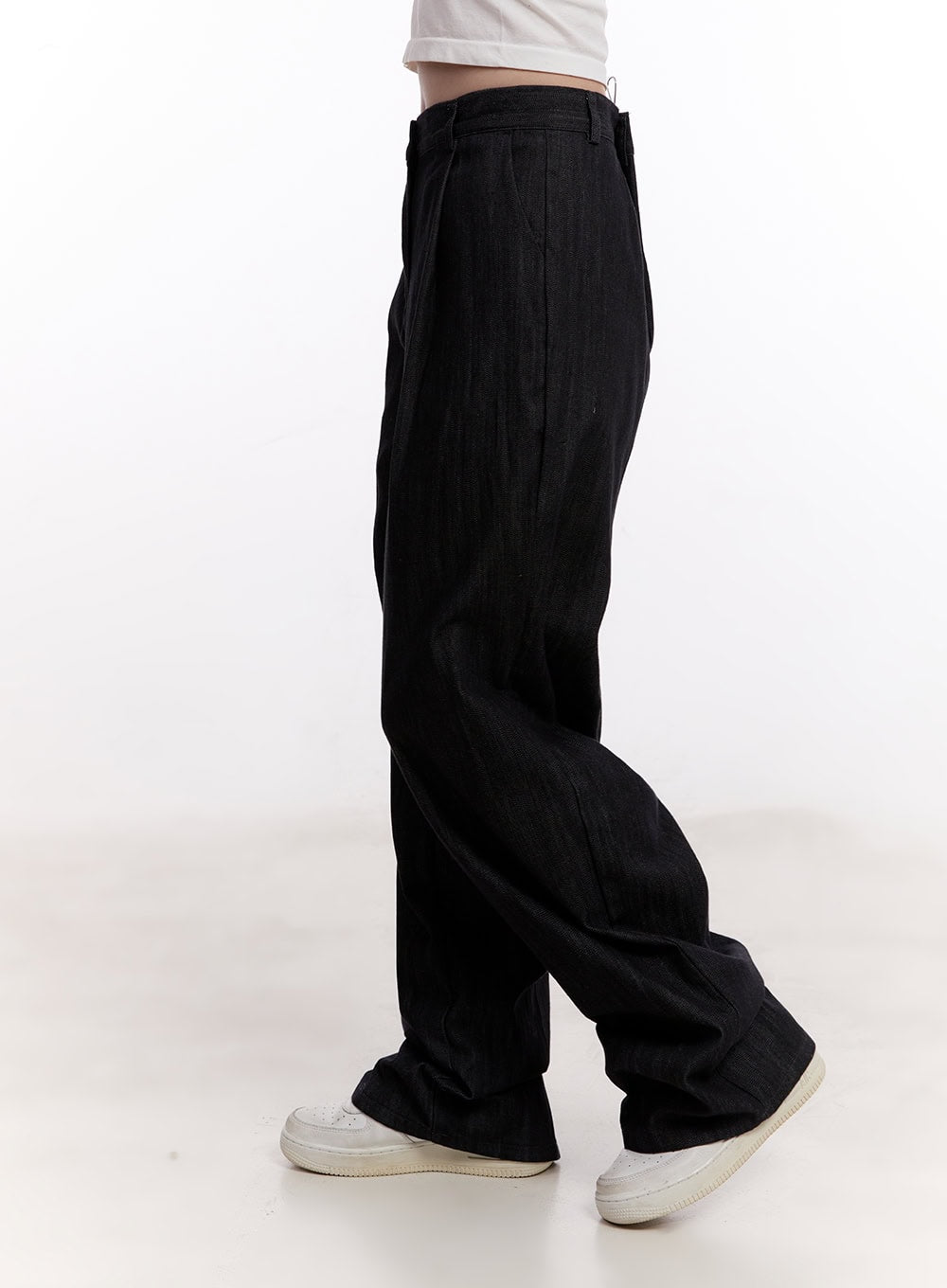 Pintuck Wide-Leg Denim Pants CM527 in black, side view on model, showing pintuck crease, high waist, and sweeping wide-leg denim cut, paired with white sneakers.