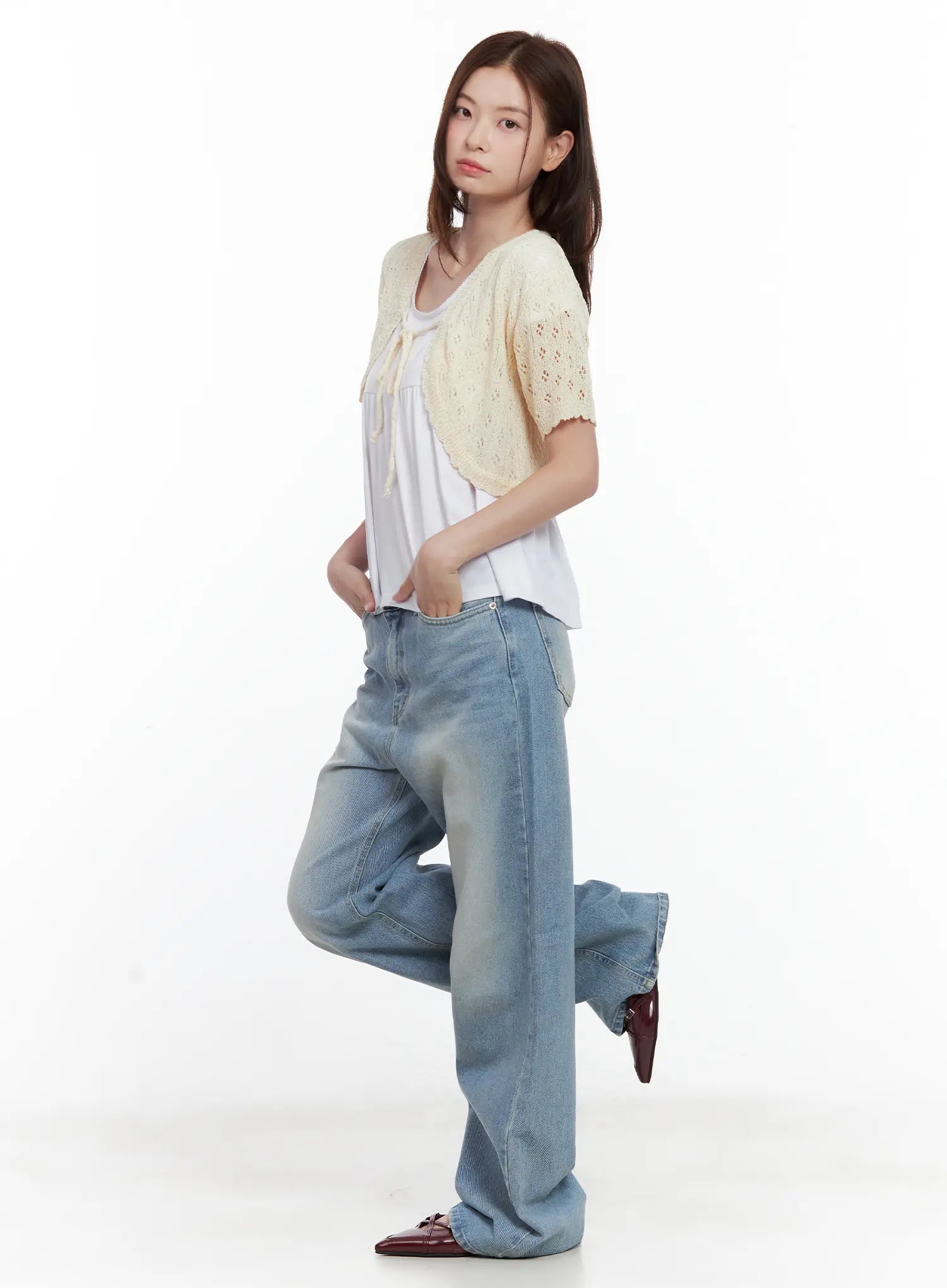 Ina Slouchy Fit Jeans CL502 in blue, side view on model with leg raised, loose wide-leg washed denim showing volume and drape, paired with white top and cream knit shrug.