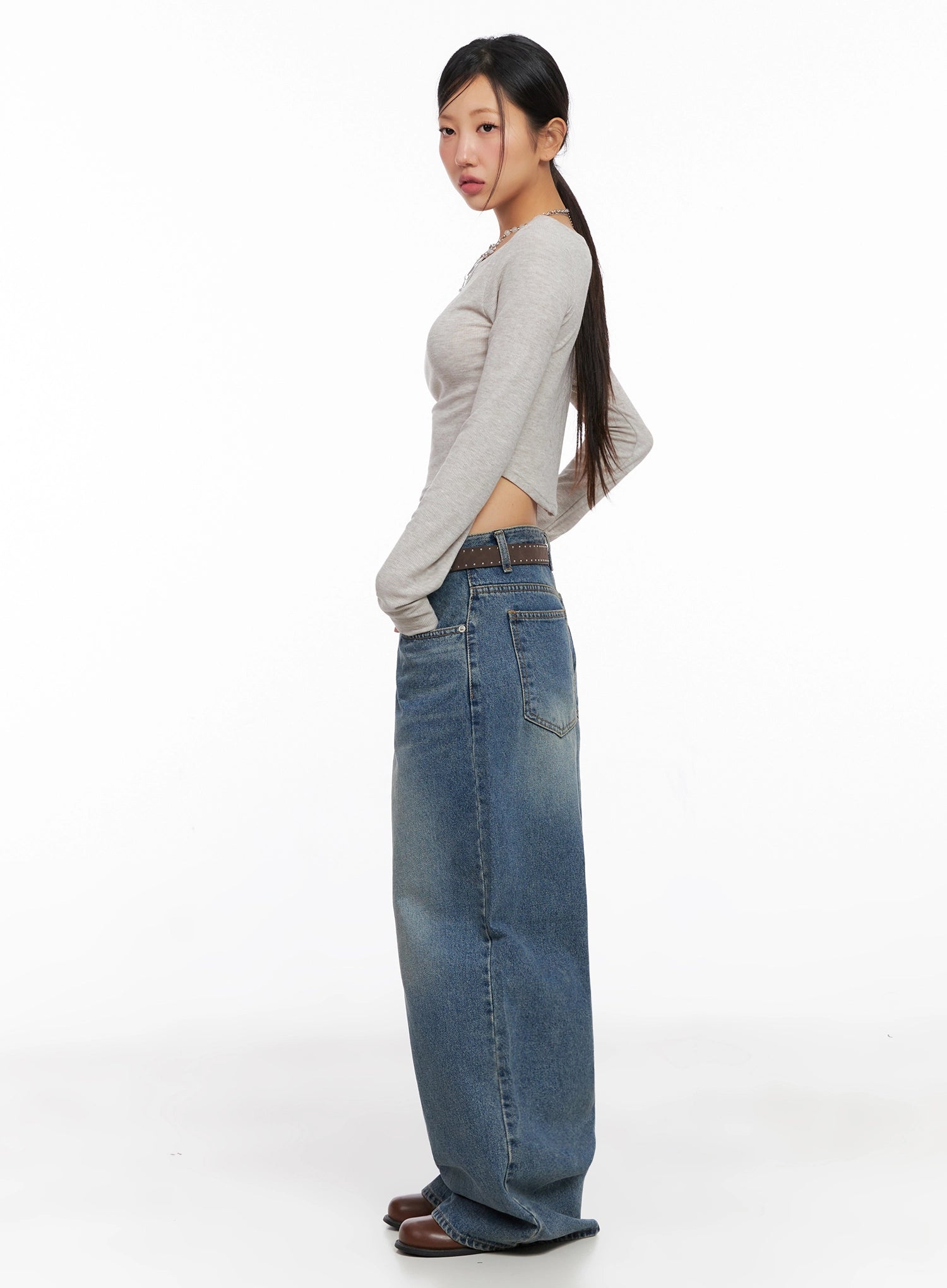 Lilah Wide-Leg Washed Jeans IG527 in mid-blue, side view on model, showing long wide leg silhouette and back pocket detail, styled with beige crop top and brown boots.