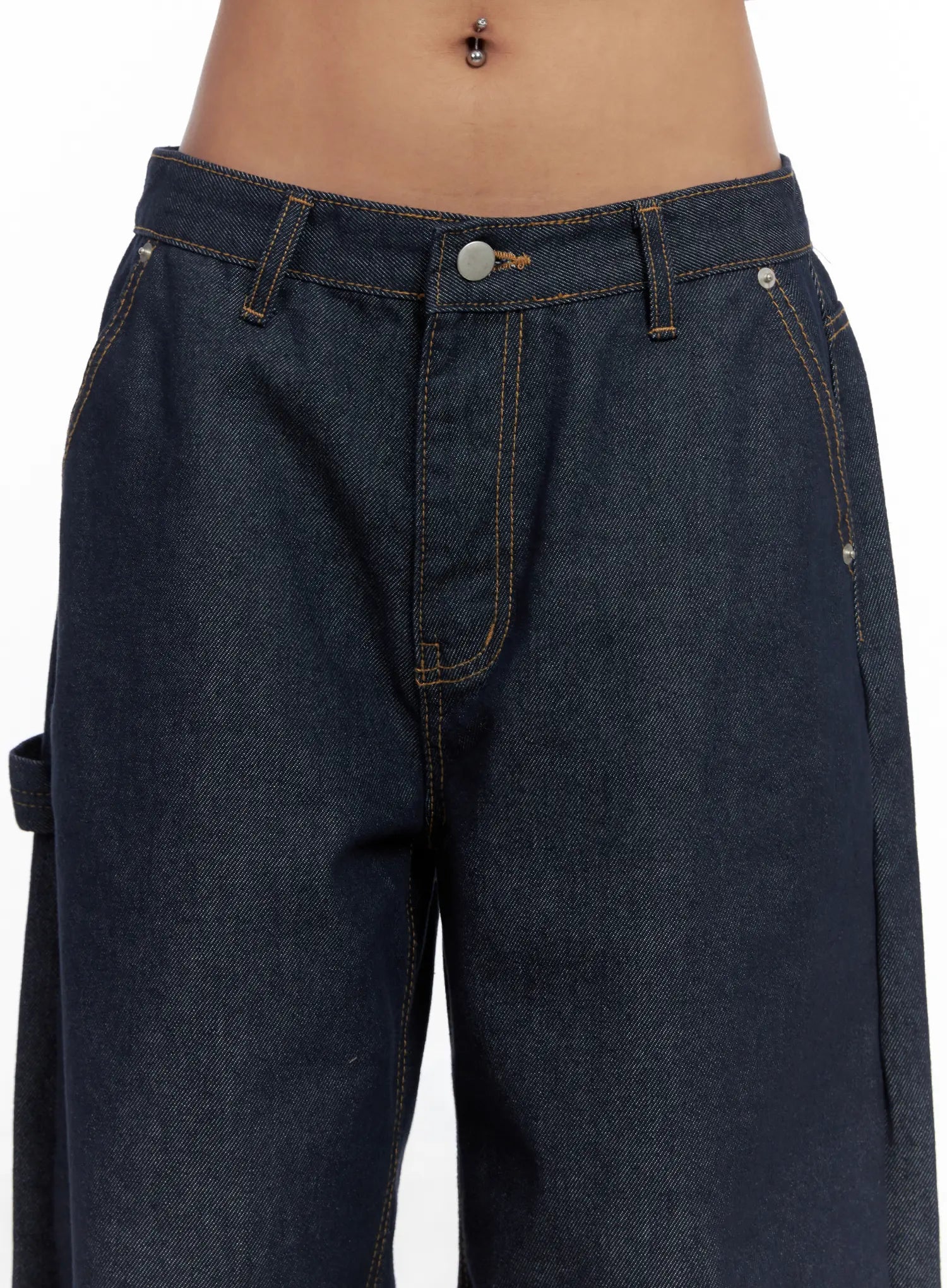 Relaxed Fit Dark Denim Jeans CS522 in dark blue, waist close-up on model, low-rise waistband with silver button, contrast gold topstitching, front pockets and carpenter loop detail visible.