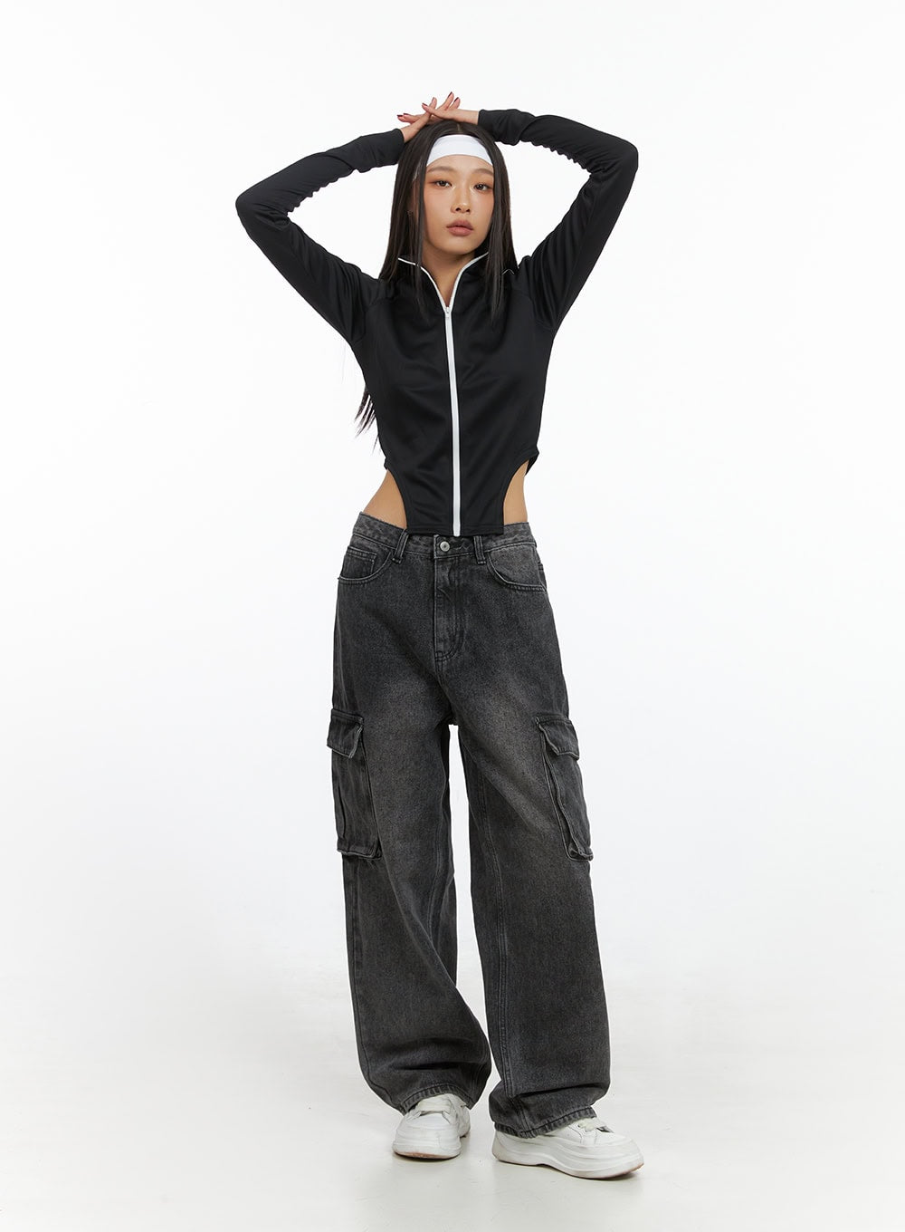 Neve Washed Cargo Denim Jeans IS427 in washed black, front full-body shot on model with arms raised, wide-leg silhouette and side cargo pockets visible, paired with black cropped zip-up top.