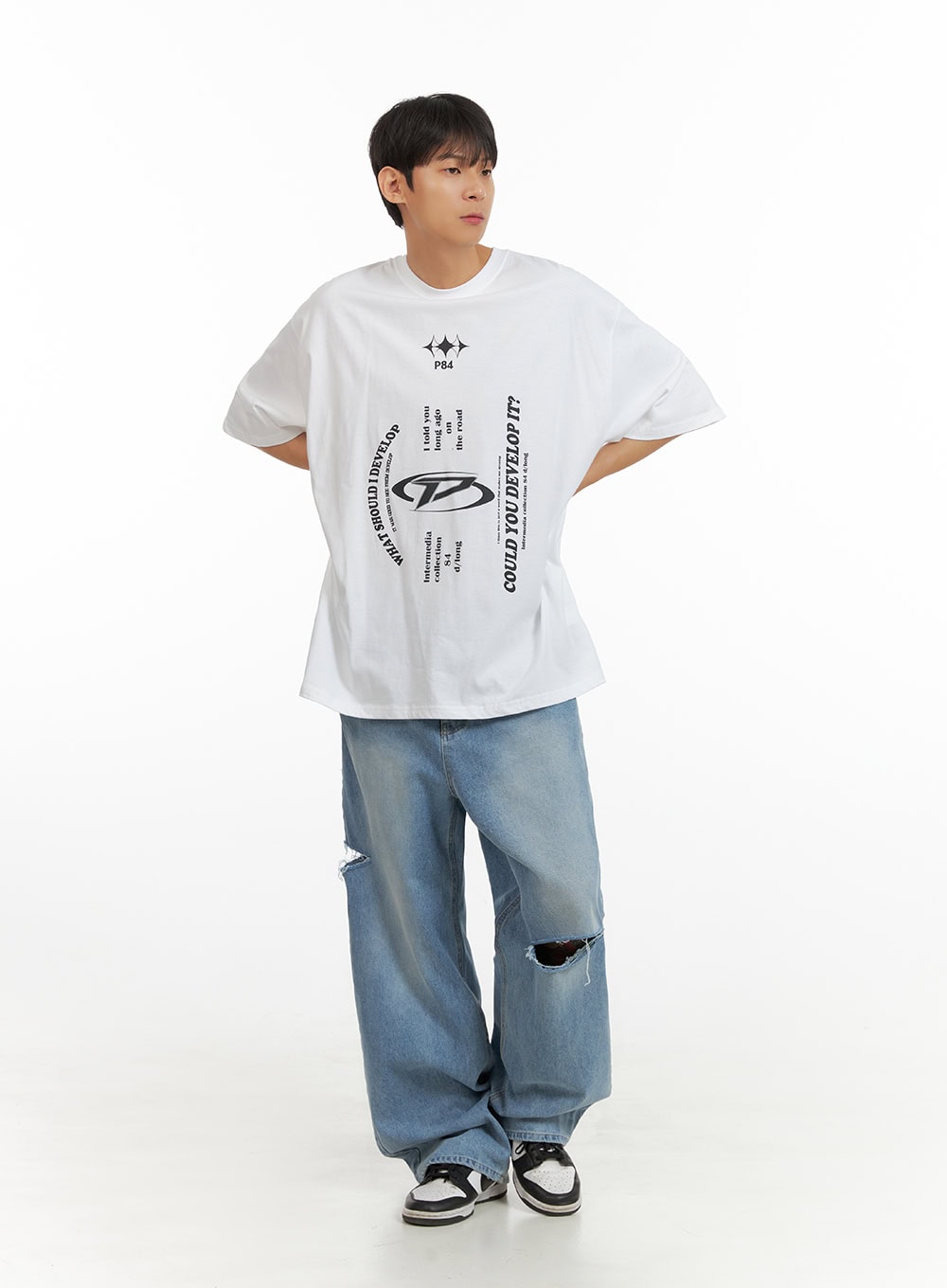 Men's Cut Out Baggy Jeans IU419 in blue, three-quarter front view on model, baggy wide-leg fit with ripped knee cut-out, paired with white oversized graphic tee and sneakers.
