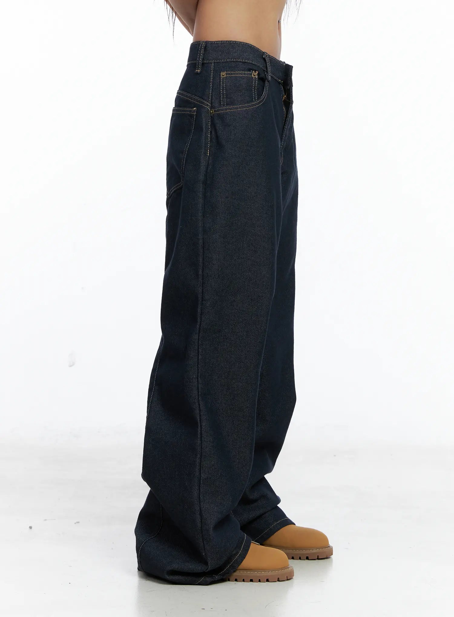 Giada Raw Indigo Wide-Leg Jeans CS505 in dark blue, side close-up on model, showing low-rise fit, straight side seam, and voluminous wide leg falling to floor with stacked hem.