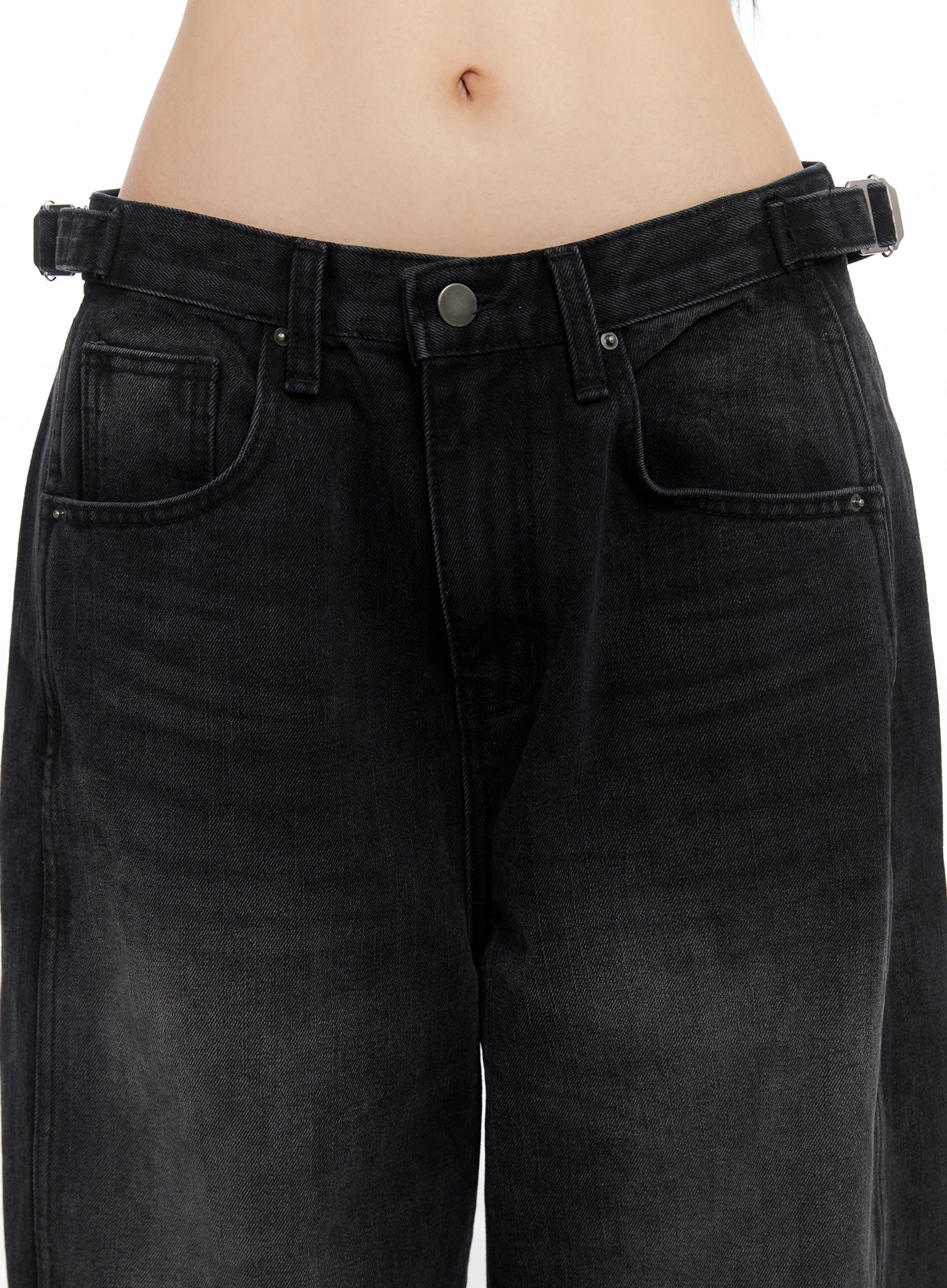 Goffel Side Belt Washed Wide Denim Pants IO517 in black, close-up of waistband area, showing side belt buckle detail, button fly, and front pockets with washed cotton texture.