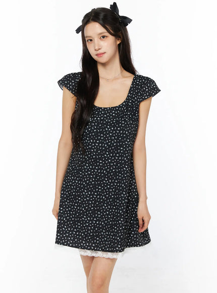 Floral Lace Trim Mini Dress CU522 in black, front view close-up on model, cap flutter sleeves, square neckline, ditsy floral print, white lace trim at hem, A-line fit.