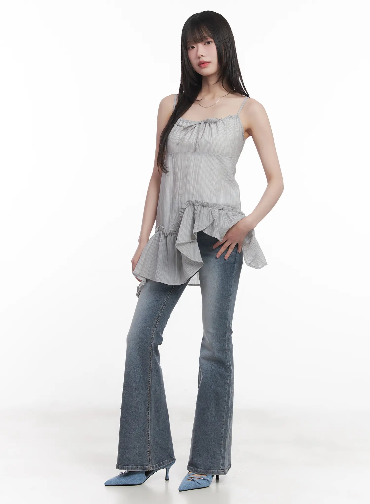 Soyeon Flared Jeans with Hip Pads CU520 in dark gray, three-quarter front on model, slim hip-pad flared jeans with washed finish, paired with gray ruffled spaghetti-strap top.