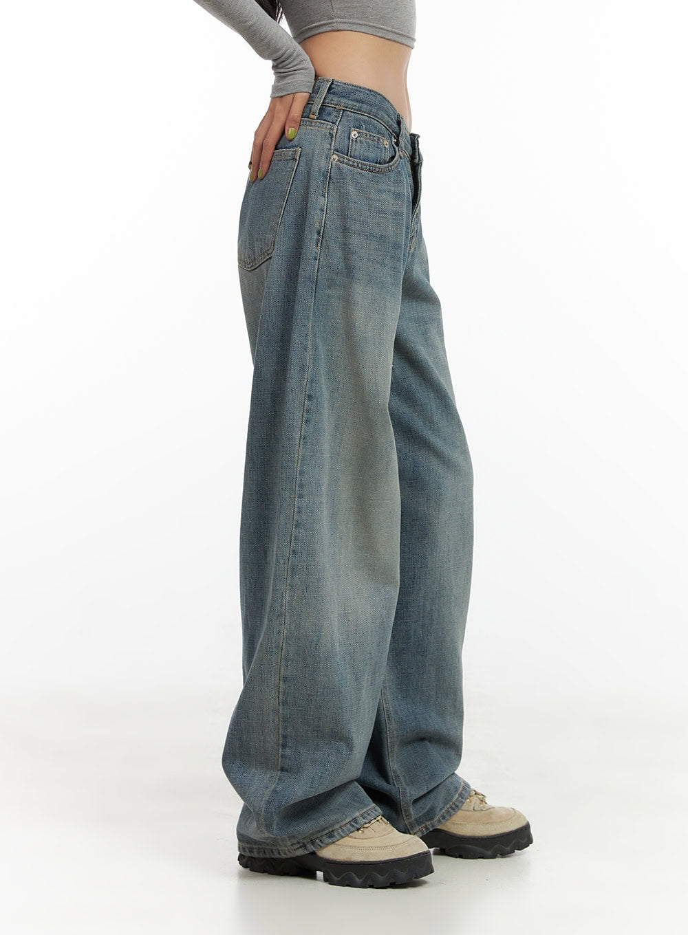 Nadia Washed Low-Waist Baggy Jeans CO424 in blue, side close-up on model, showing low-rise waistband, relaxed wide silhouette, washed cotton-denim blend with subtle fading, paired with grey crop top.