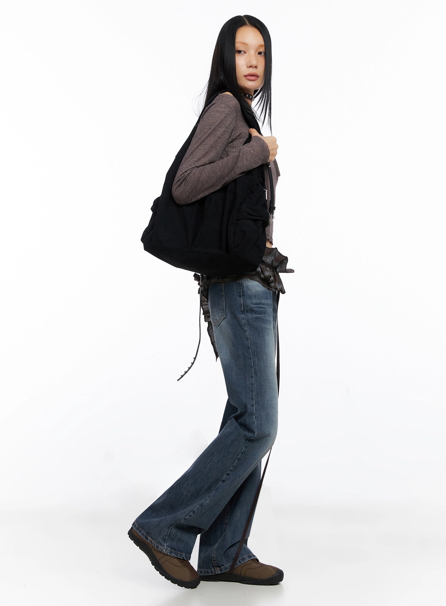 Myra Washed Bootcut Jeans IO516 in dark blue, side view on model walking, bootcut silhouette visible, paired with brown knit crop top and black oversized tote bag.