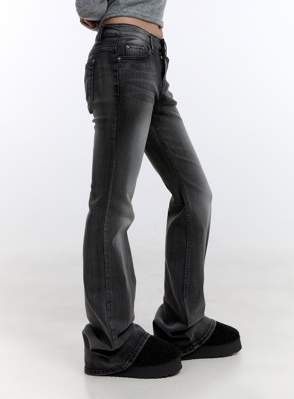 Gianna Faded Flared Jeans CO422 in Black, side view on model, slim-fit low-rise faded denim showing subtle flare at hem, styled with grey crop top and black shearling shoes.