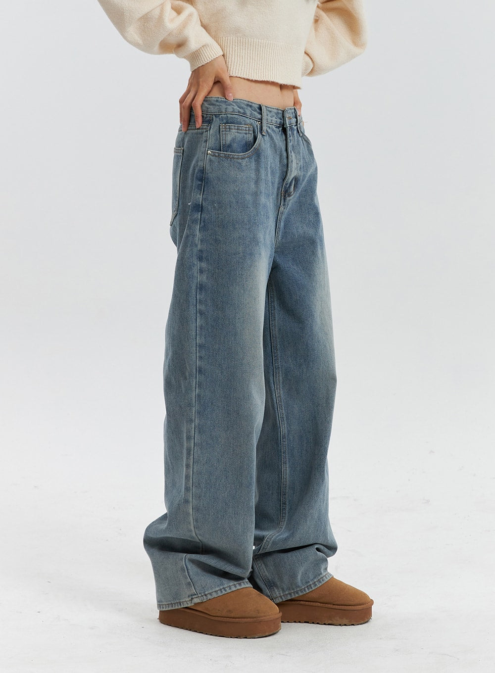 Mid Waist Washed Button Wide Leg Jeans OD320 in blue, side view on model, showing relaxed wide-leg silhouette, washed fading along thigh, and pooling hem over platform boots.