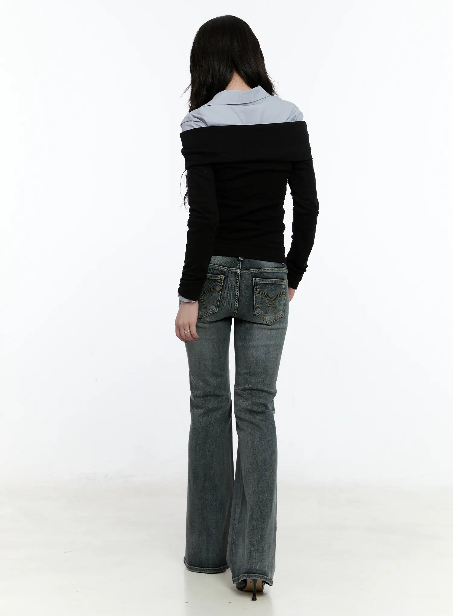 Judith Washed Bootcut Jeans CN517 in blue, full-length back view on model, showing decorative arc-stitched back pockets and bootcut hem flare, styled with black top.