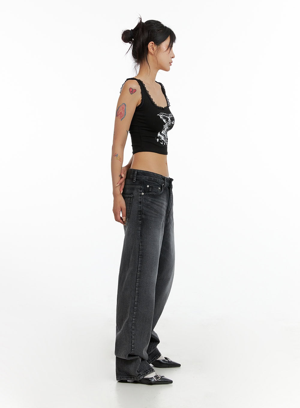 Low Rise Wide Leg Jeans CL415 in black, side view on model, low-rise waistband and relaxed wide leg silhouette, washed denim, paired with black crop tank and mules.