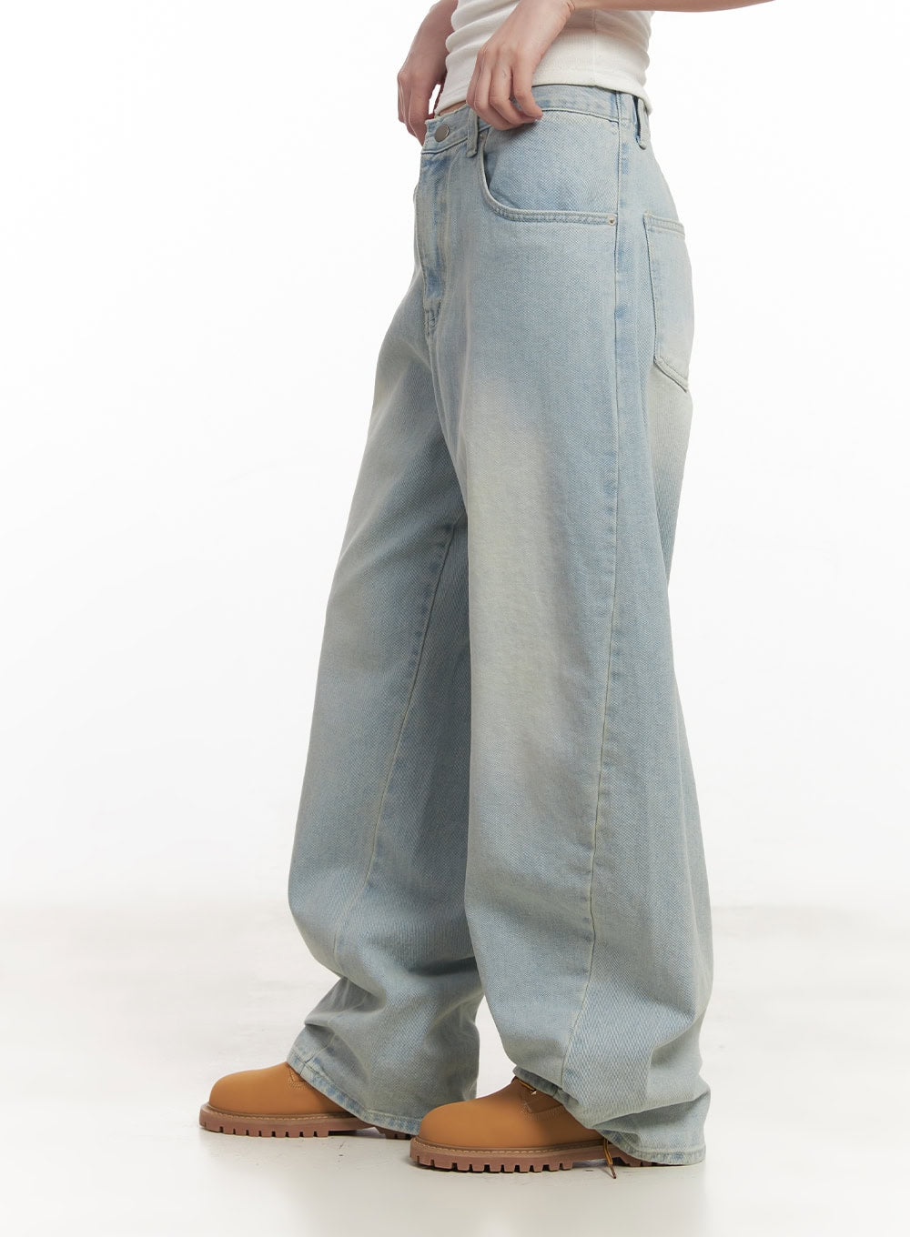 Alia Washed Wide-Leg Jeans CA518 in light blue, side-view close-up on model, showing exaggerated wide-leg sweep, faded wash, patch pocket detail, and floor-grazing hem pooling over boots.
