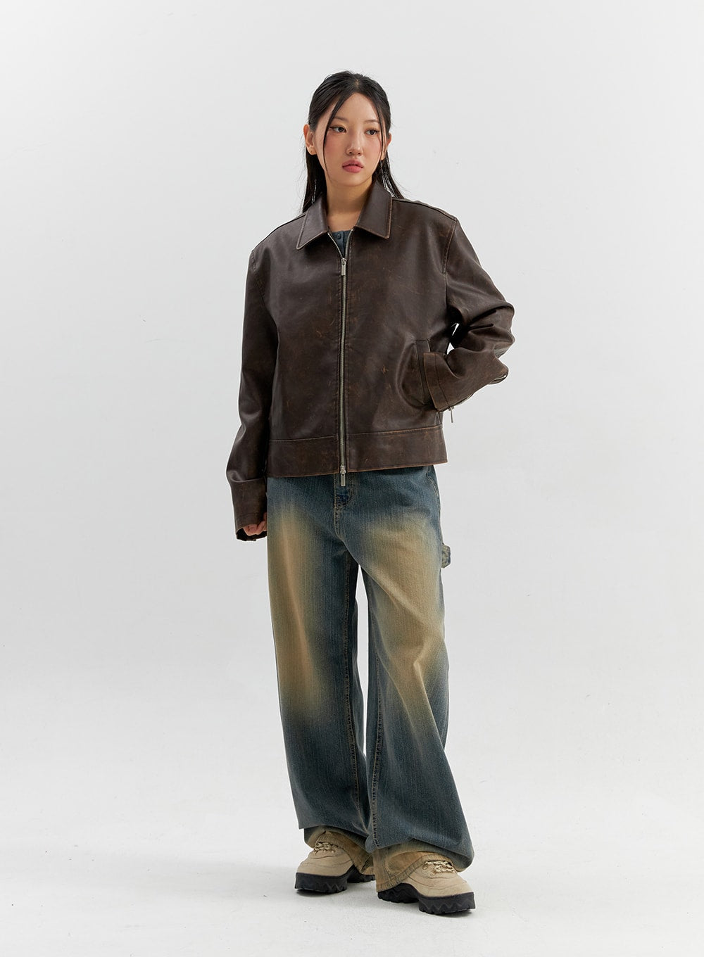 Vintage Wash Wide Leg Jeans CO306 in blue, full-body front view on model, relaxed wide-leg cotton denim, vintage yellow fading, styled with brown zip-up leather jacket.