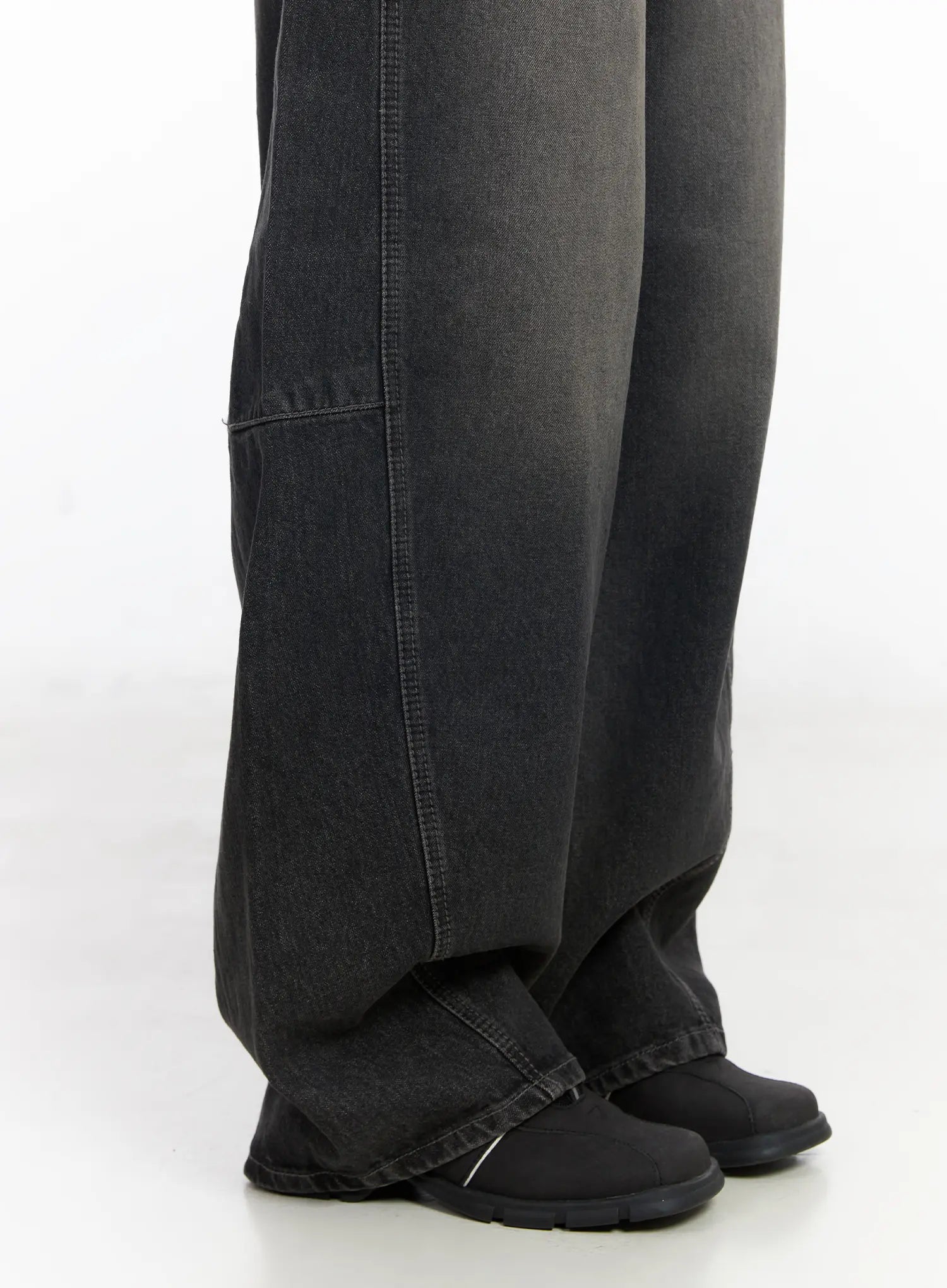 Nayeli Baggy Jeans CJ522 in dark gray, close-up hem and ankle detail on model, ultra-wide leg pooling over black sneakers, washed cotton with visible seam panel.