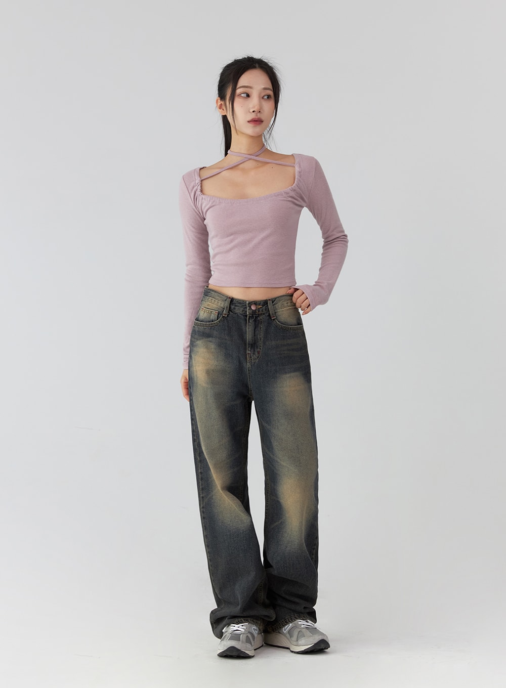 Wide Leg Jeans CD322 in dark blue, slightly angled front view on model, size L, vintage washed denim with yellow fading at thighs, wide fit, paired with pink cross-neck crop top and sneakers.