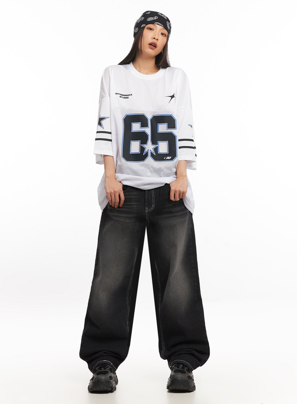 Alexis Stitched Wide-Leg Jeans IA504 in washed black, front full-length on model standing straight, wide-fit cotton denim with visible contrast white stitching, paired with graphic football jersey.