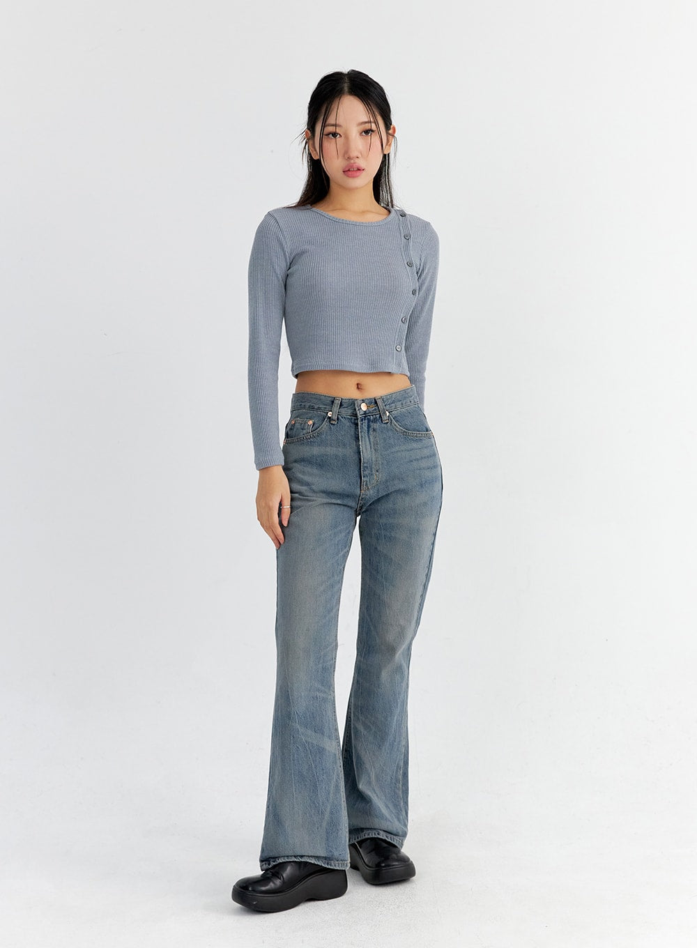 Vintage Washed Bootcut Jeans CO325 in blue, full-body front shot on model standing straight, slim fit washed denim with flared hem, styled with grey ribbed crop top and black platform loafers.