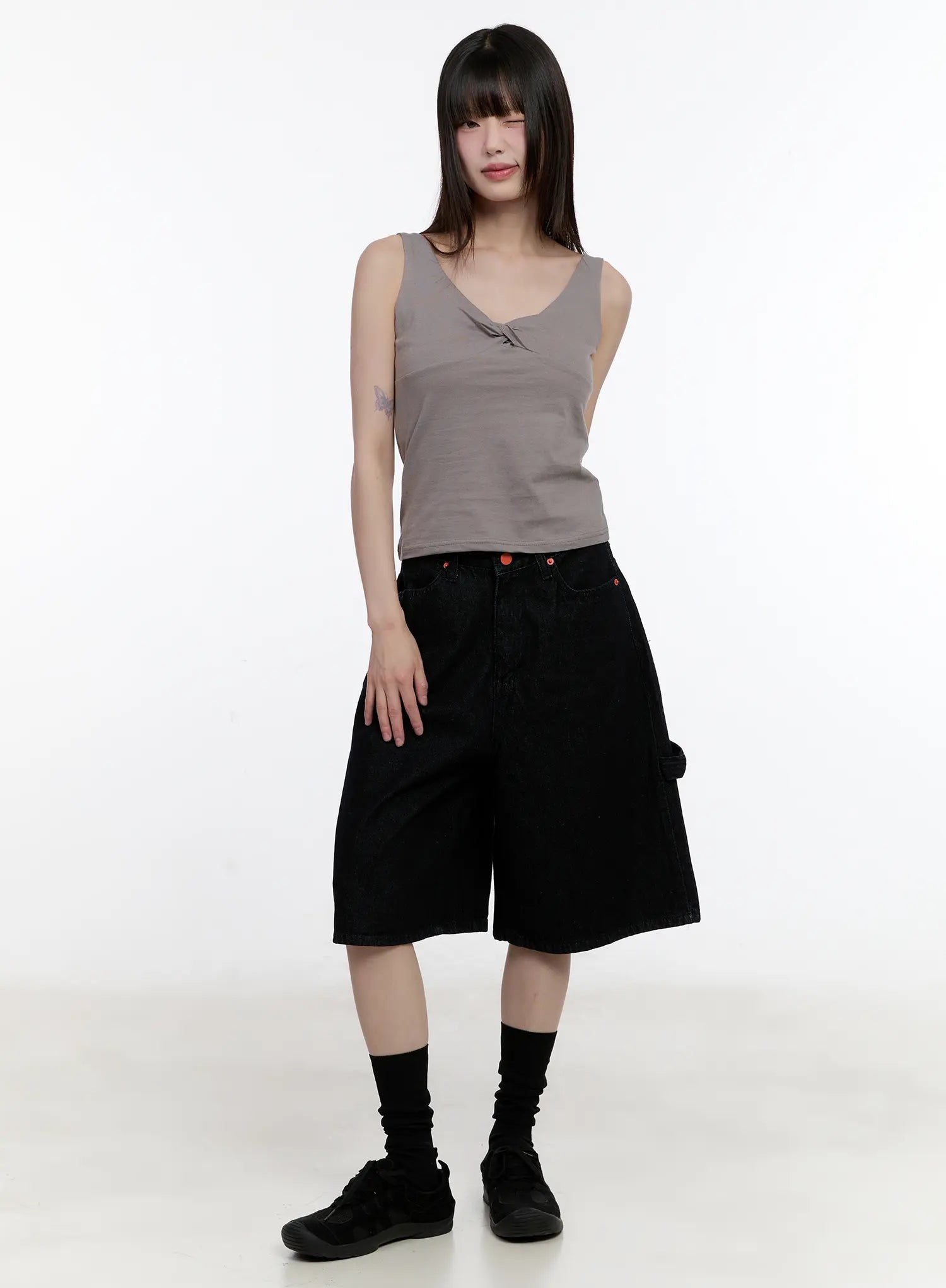Red Text Graphic Embroidered Jorts CL504 in black, full front view on model, loose wide-leg fit, red rivet buttons, half length, styled with gray tank top and black sneakers.